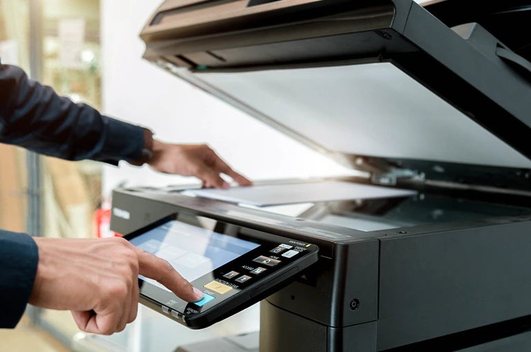 Commercial printer operator using a digital printing machine for high-quality custom print production