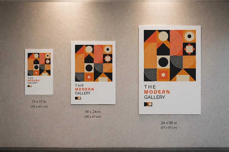 Poster size comparison on the wall showing 11x17, 18x24 and 24x36 inch modern gallery prints in an interior space