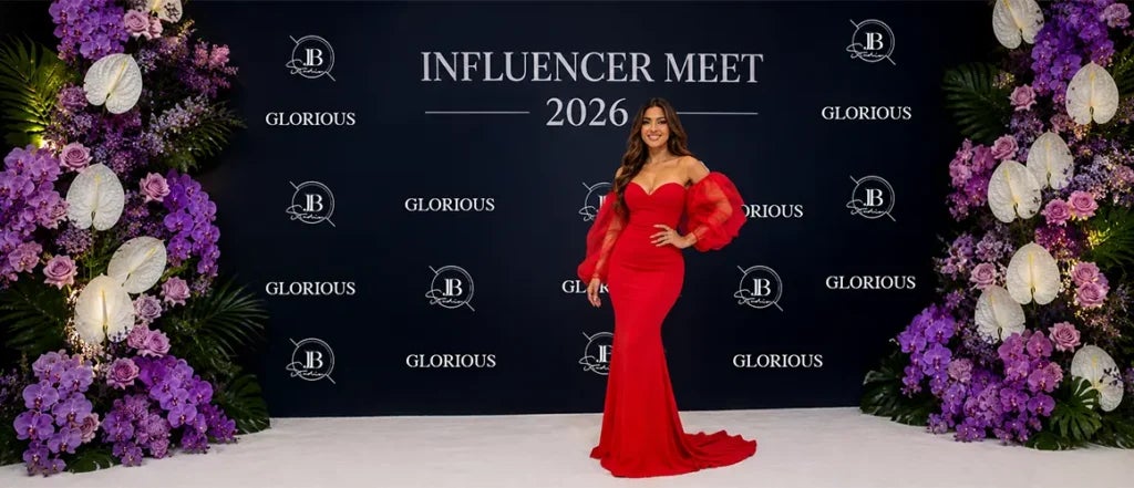Influencer posing in front of a custom step and repeat banner at an event